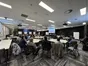 A large seminar room with about forty people at tables, watching a speaker present slides on two screens.